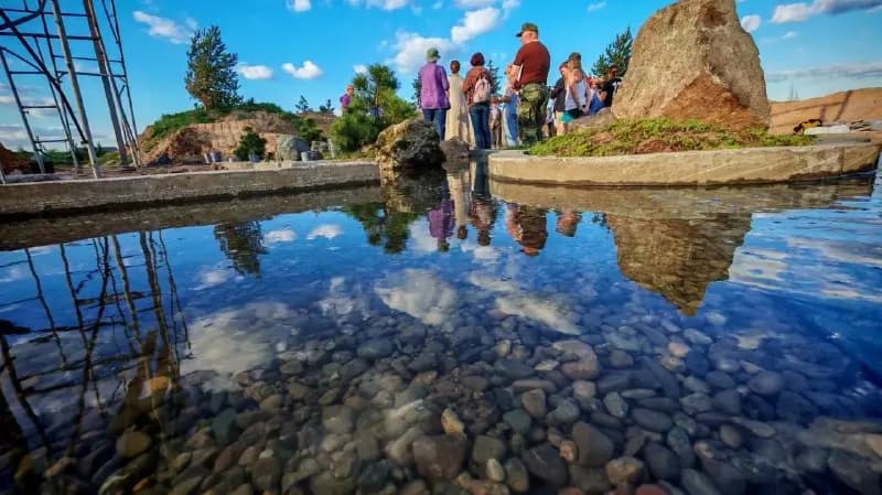 Водная гладь с отражением неба и каменным островом